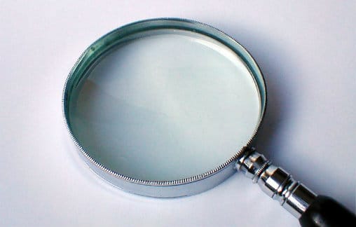Picture of person looking at a tablet with magnifying glass