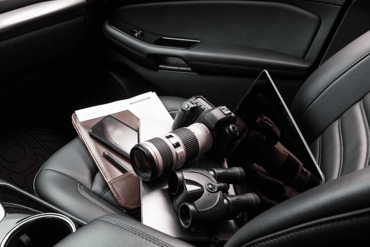 Cameras and other surveillance tools in the front passenger seat of a vehicle used by a private investigator to properly conduct surveillance.