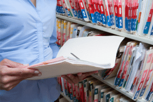 Medical staff checking a chart to verify if a patient was treated at their facility for medical background investigators.