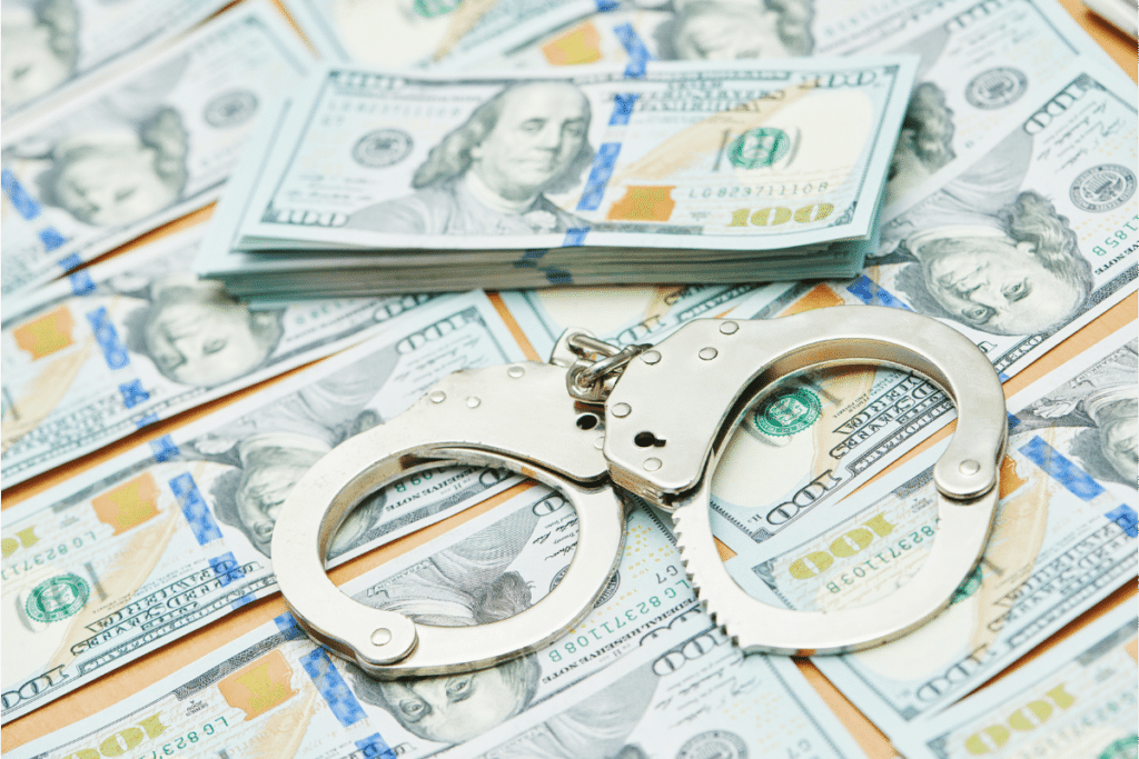 Image of money and handcuffs to depict the potential impact of and penalties for committing workers' compensation fraud.